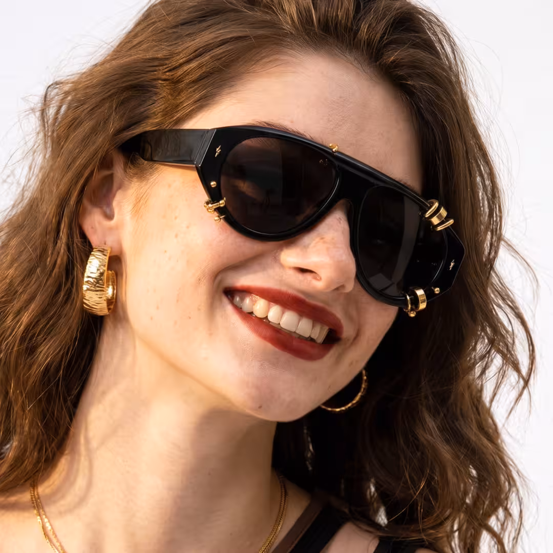 Front view of female wearing gold aviator sunglasses, smiling, AP0082604