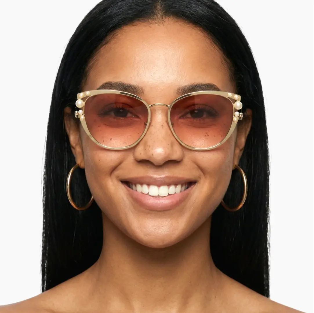 Front view of female wearing pink cat eye sunglasses, smiling, CM0042505