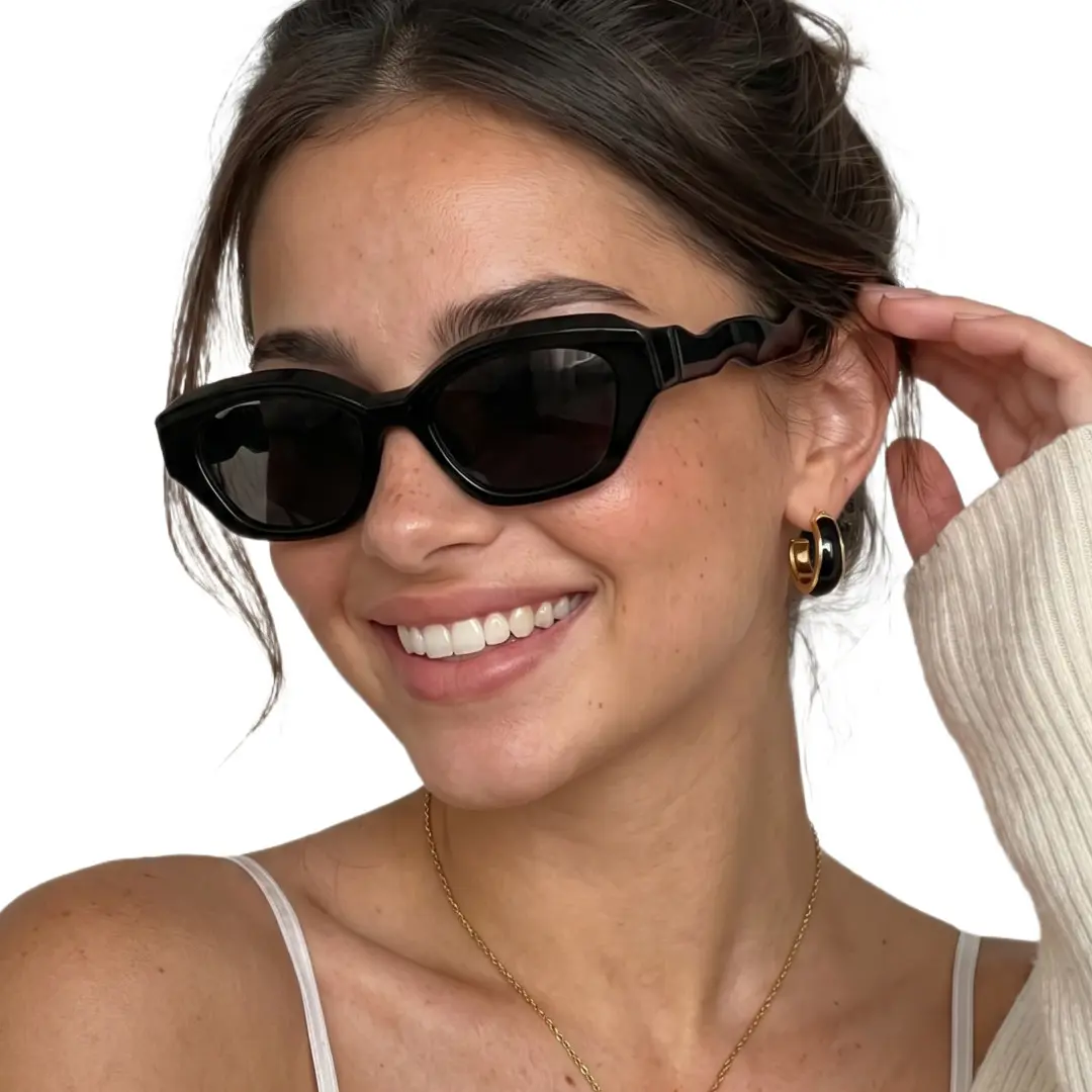 Three-quarter view of female wearing fashion black cat eye sunglasses, hand on temple, smiling, CP0052604