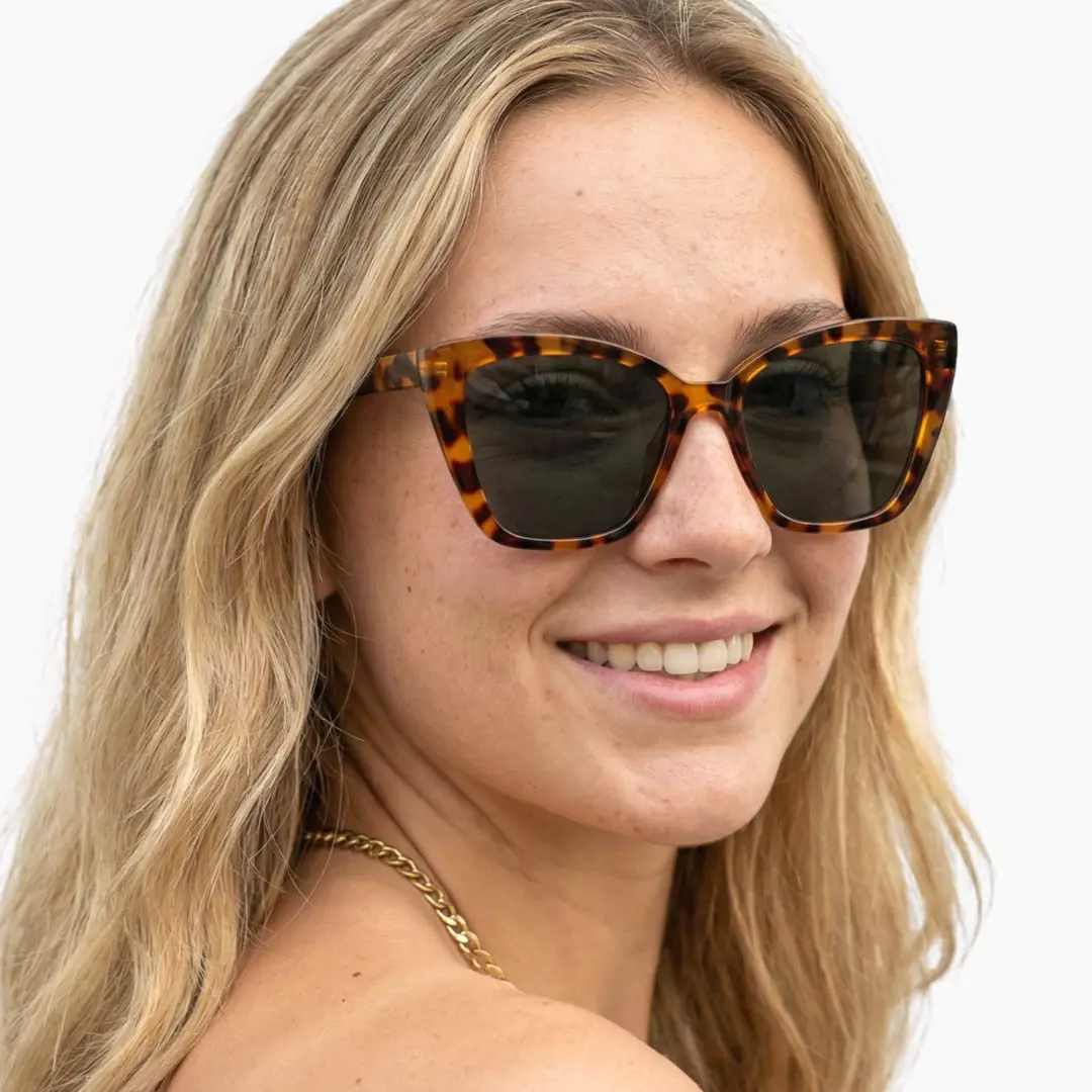 Front view of female wearing tortoise cat eye sunglasses, natural smile, CP0102506