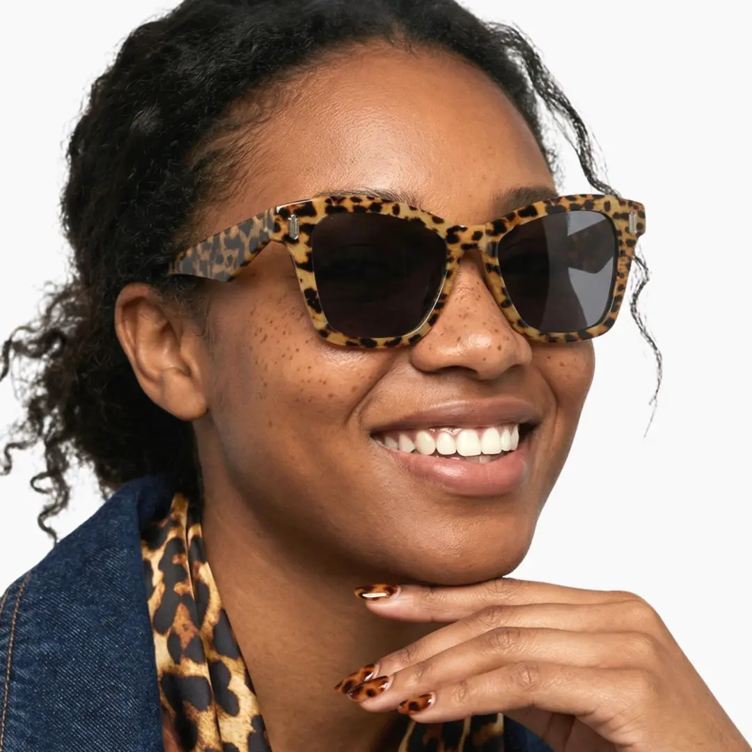 Profile view of female wearing tortoise cat eye sunglasses, natural smile, CP0122506