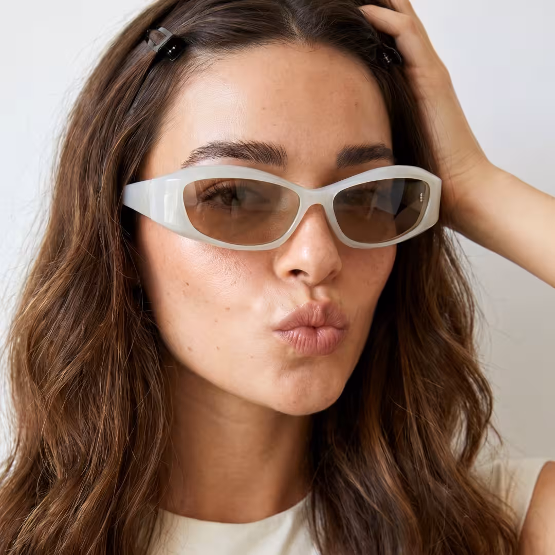 Three-quarter view of female wearing y2k green cat eye sunglasses, pouting, hand in hair, CP0172603