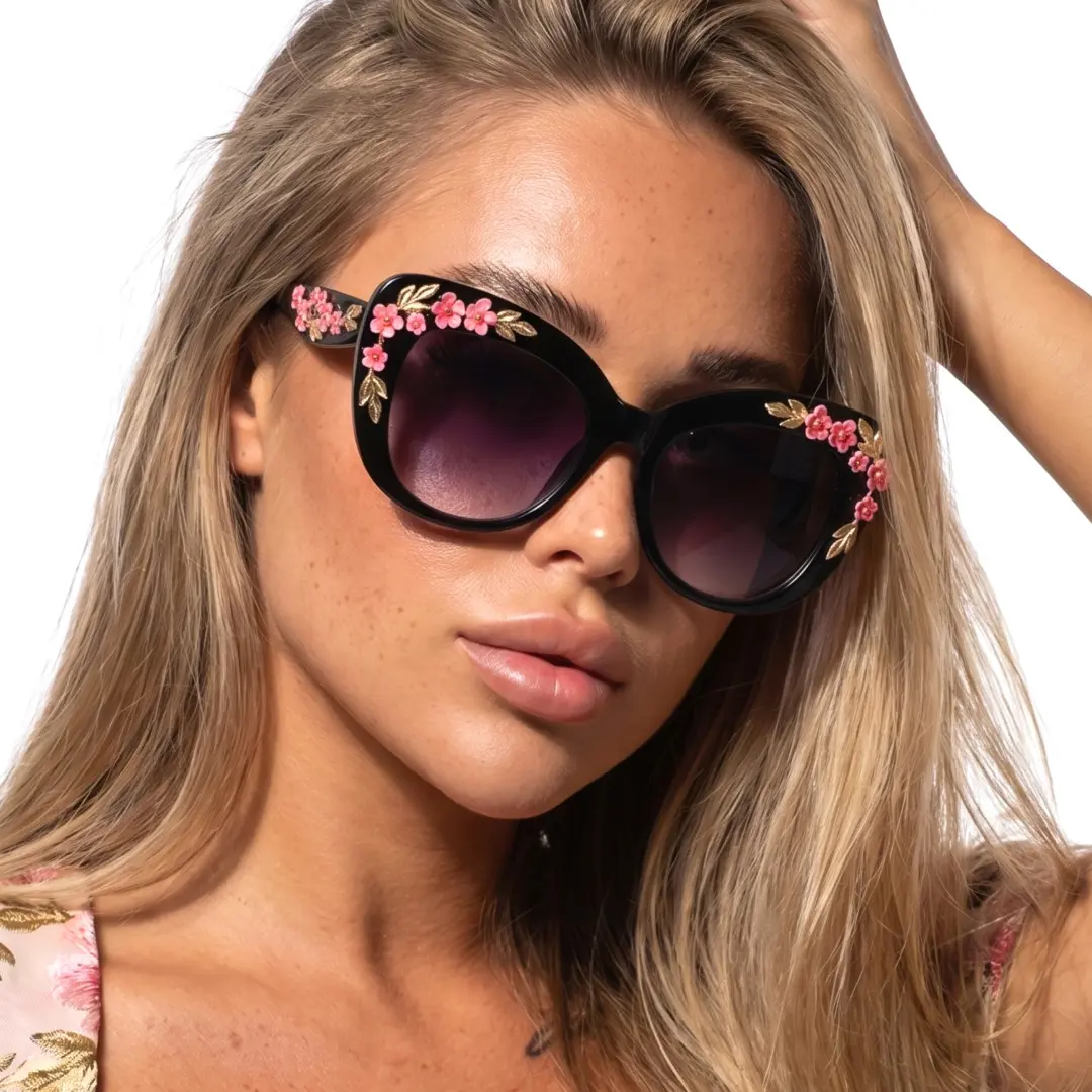 Three-quarter view of female wearing black cat eye sunglasses, hand in hair, neutral expression, CP0262507