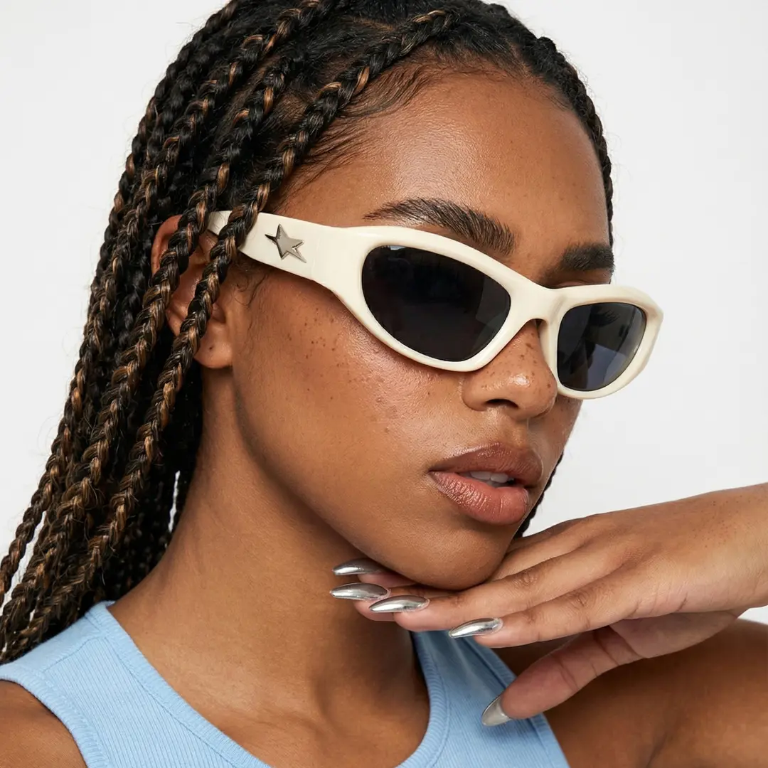 Three-quarter view of female wearing beige cat eye sunglasses, resting chin on hand, natural expression, CP0302603