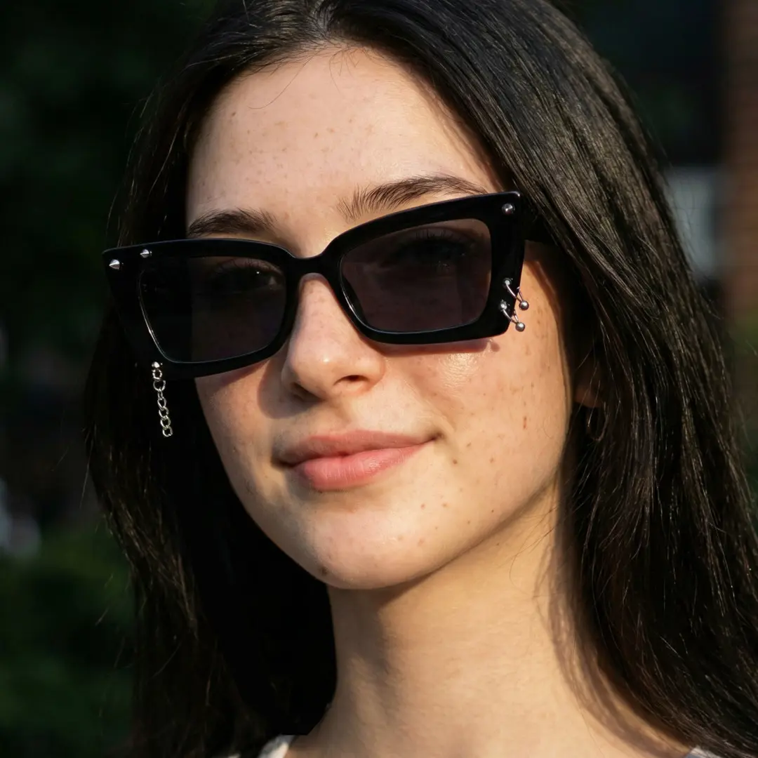 Three-quarter view of female wearing black cat eye handcrafted polarized sunglasses, natural expression, CR0032509