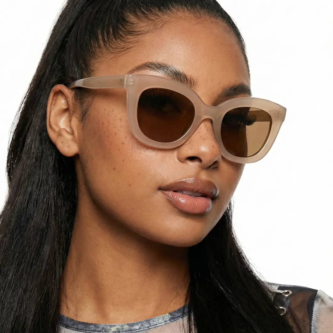 Front view of female wearing beige cat eye sunglasses, tilting head, confident expression, CR0172404