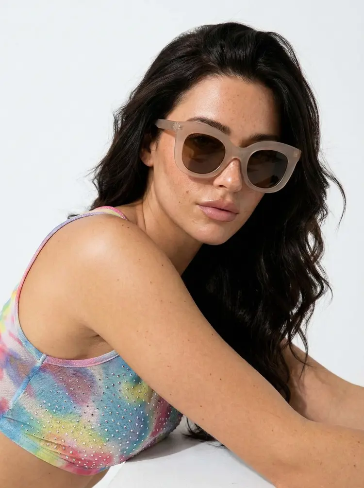 Female model wearing everyday brown cat eye tr90 sunglasses in a colorful tie-dye top against a solid white studio background. SPU: CR0172404