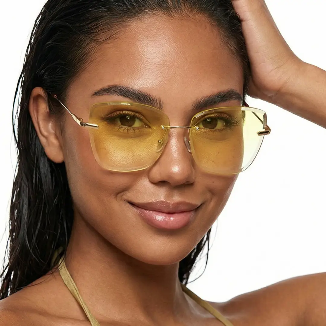 Three-quarter view of female wearing yellow cat eye sunglasses, hand on head, soft smile, CX0102505