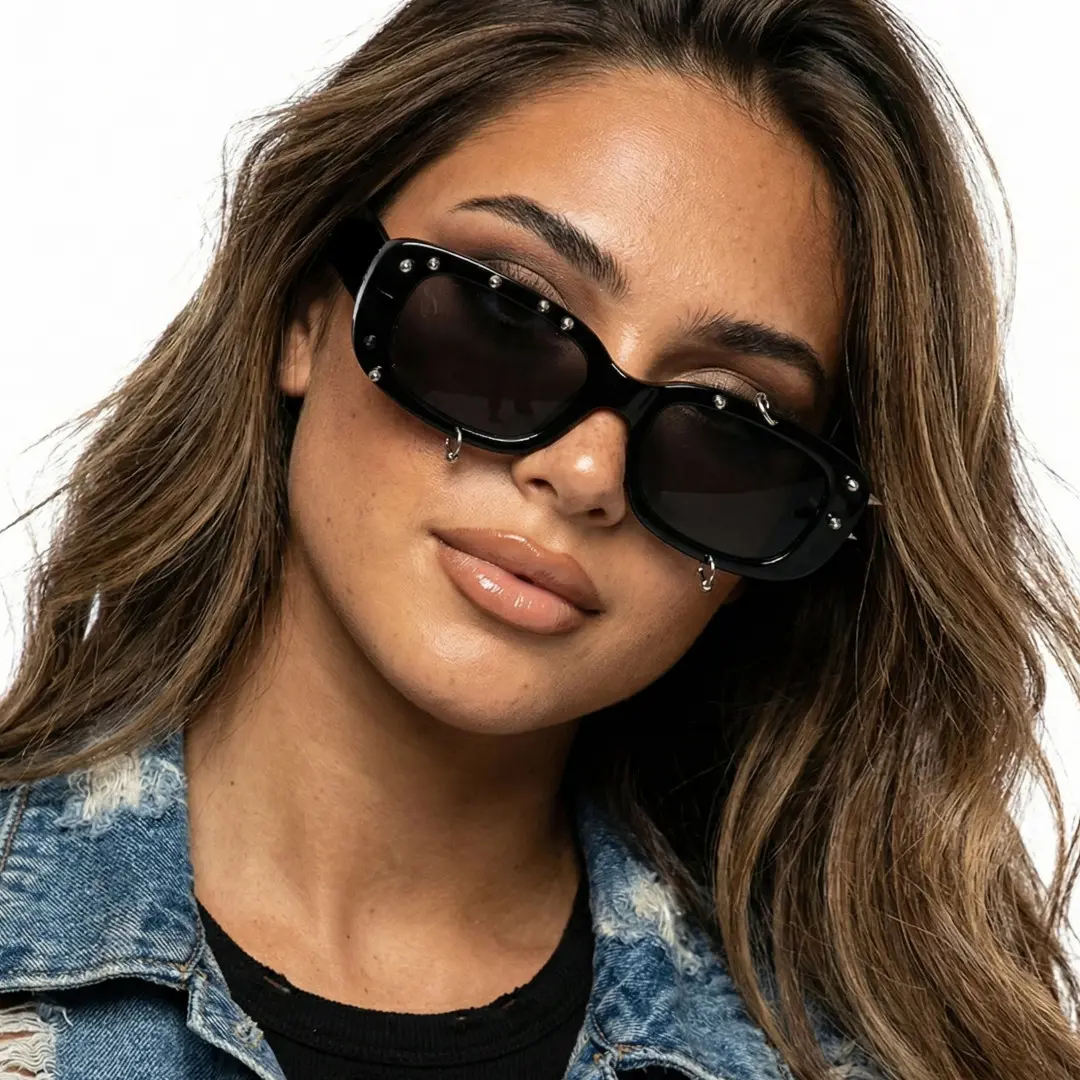 Front view of female wearing black rectangle sunglasses, tilting head, neutral expression, EP0022511