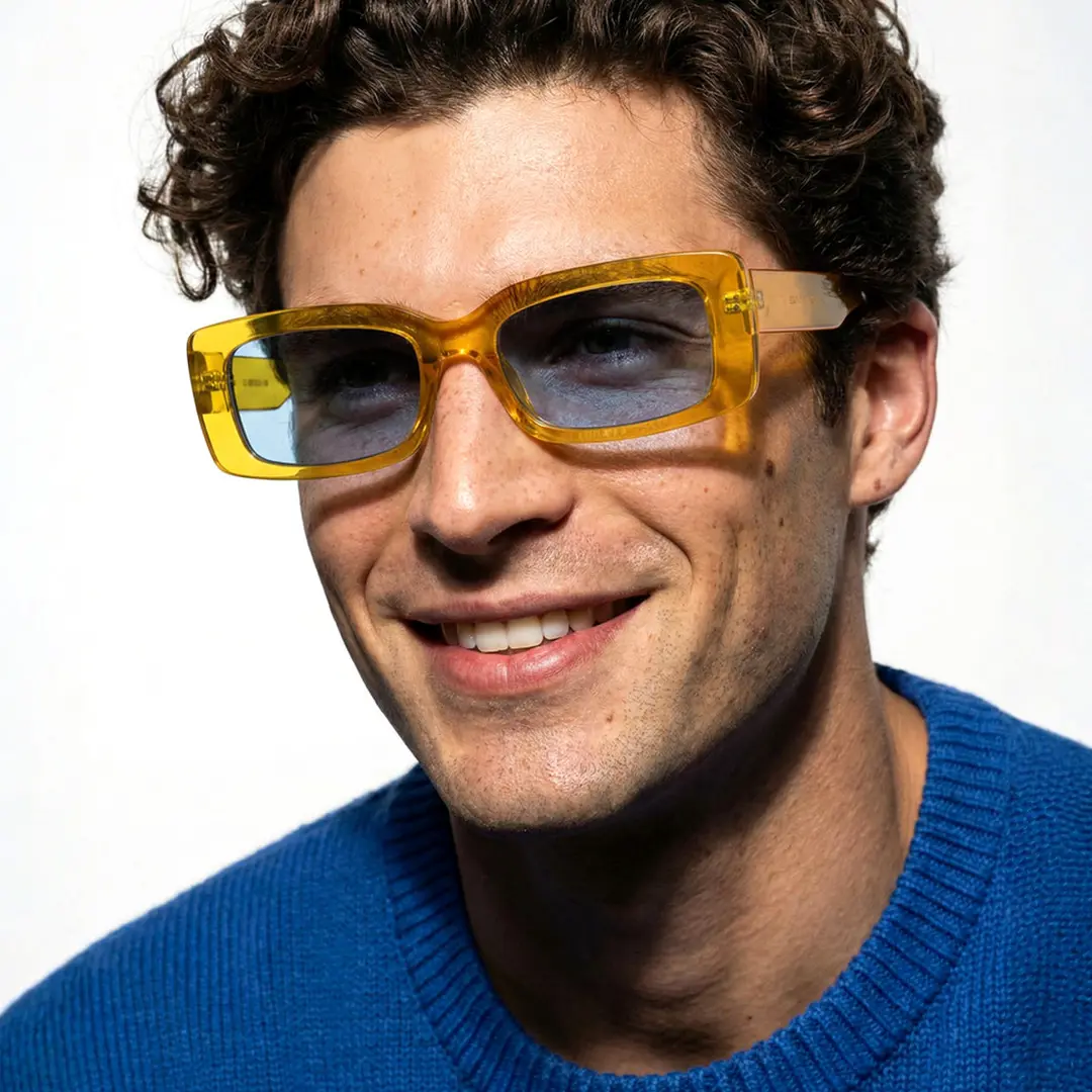 Slightly angled view of male wearing fashion yellow rectangle sunglasses, natural smile, EP0042212