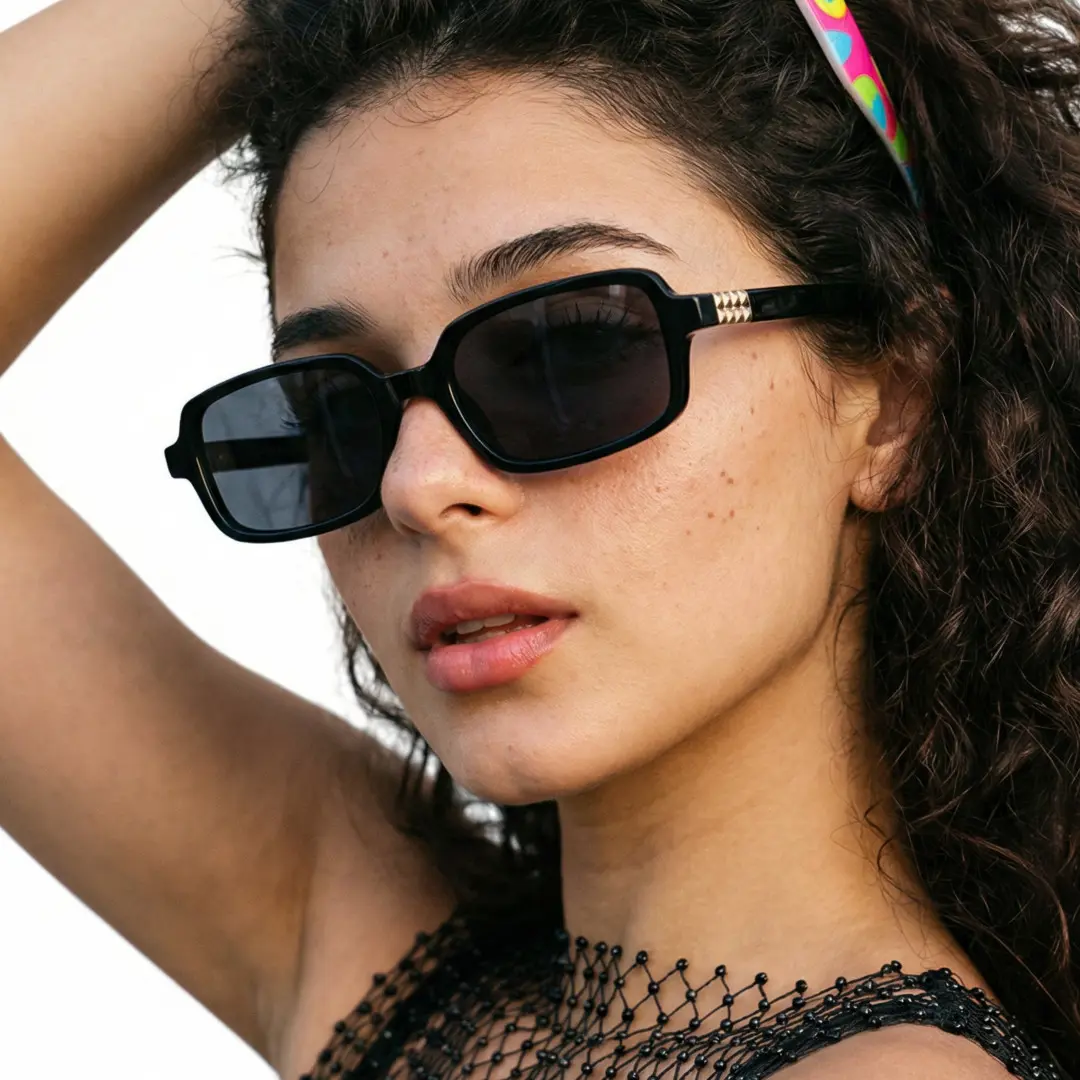 Front view of female wearing vintage black rectangle sunglasses, hand in hair, relaxed expression, EP0172507