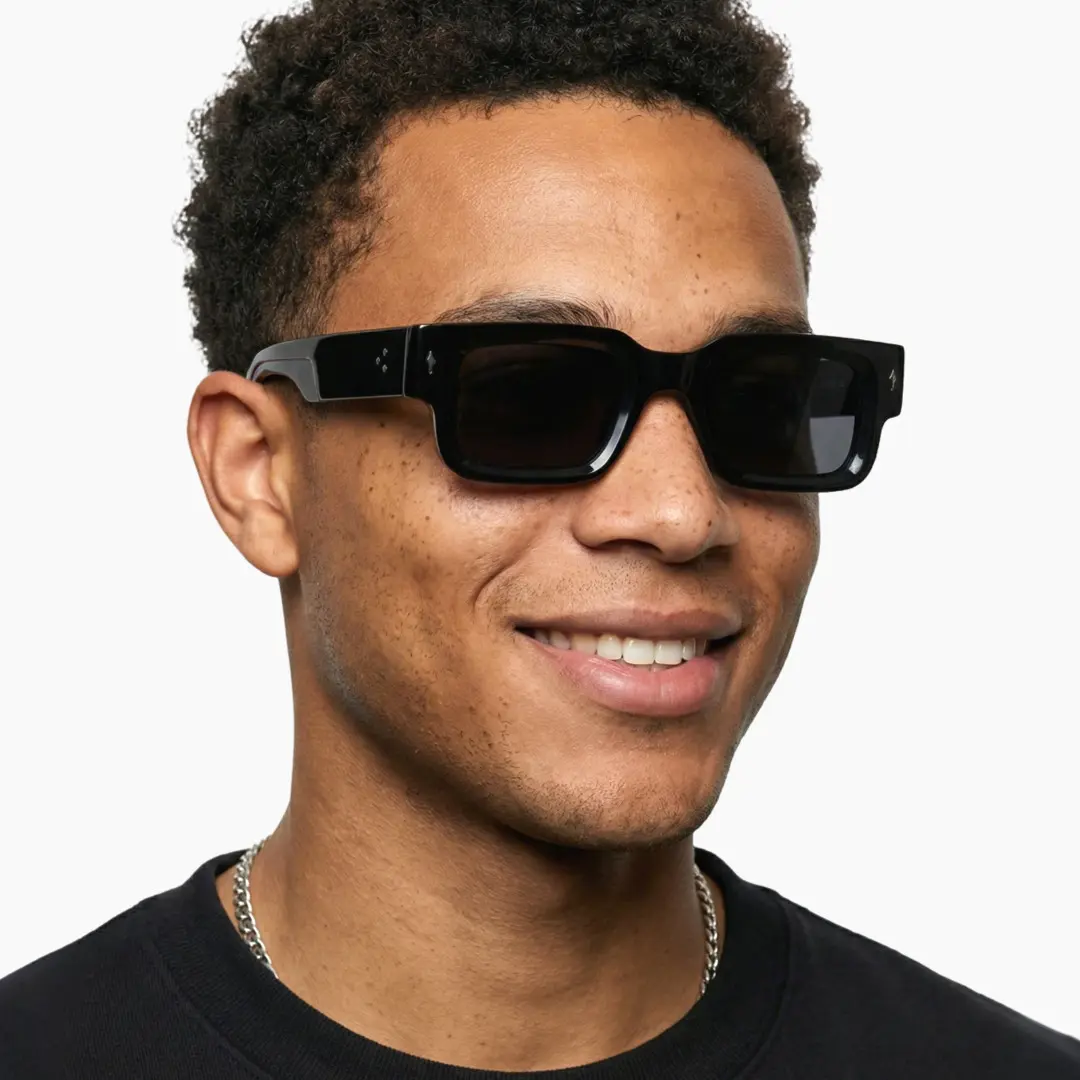 Looking away view of male wearing black rectangle sunglasses, natural smile, EP0542509S