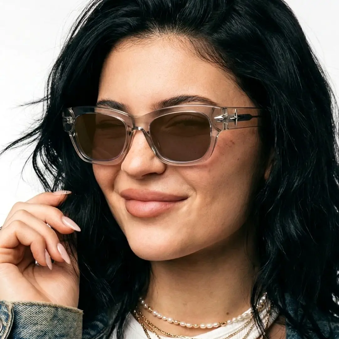 Three-quarter view of female wearing fashion brown rectangle sunglasses, hand near face, natural smile, ER0022604