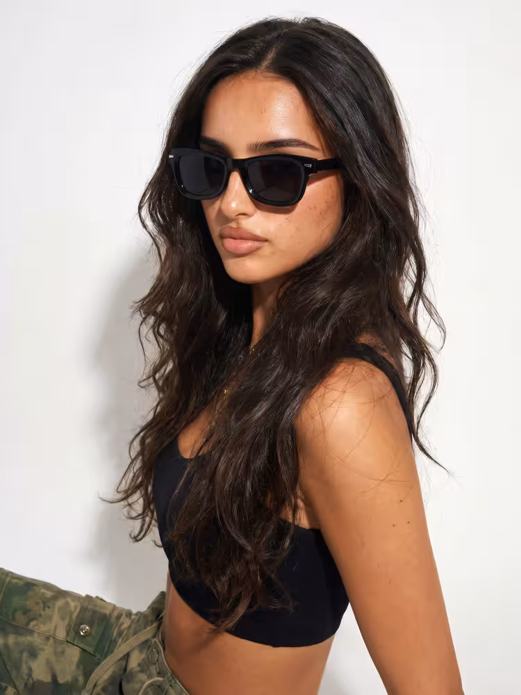 Female model wearing trendy black rectangle tr90 sunglasses in studio setting. SPU: ER0112604