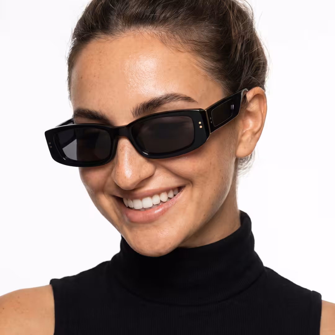 Three-quarter view of female wearing fashion black rectangle sunglasses, natural smile, ER0132604