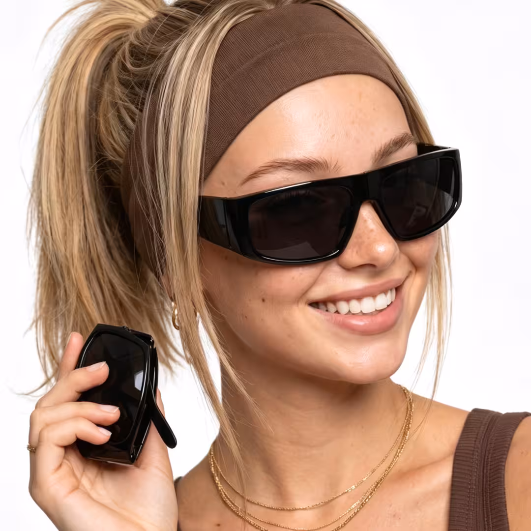 Female wearing y2k black rectangle tr90 sunglasses, smiling while holding glasses. SPU: ER0132605