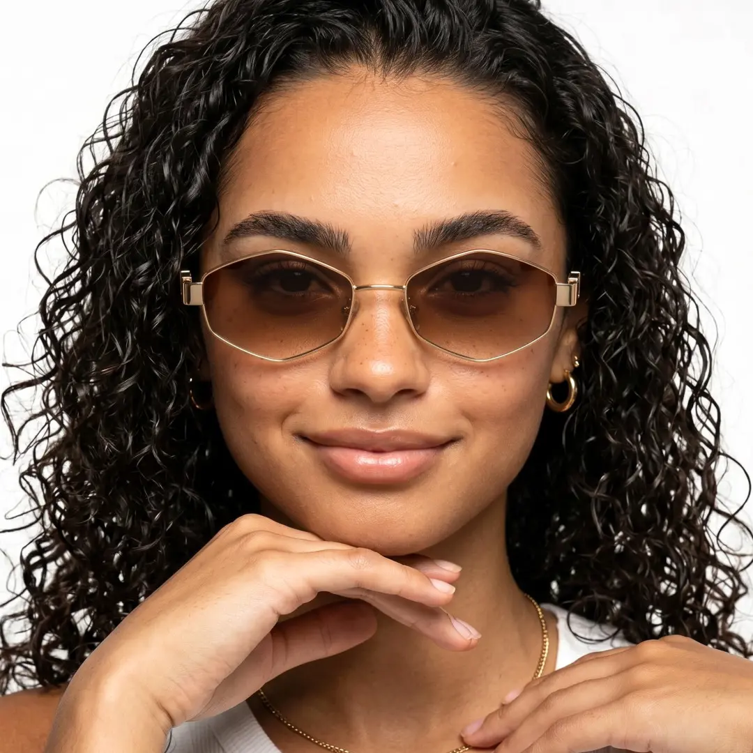 Face close-up view of female wearing gold geometric sunglasses, resting chin on hand, neutral expression, GM0282603