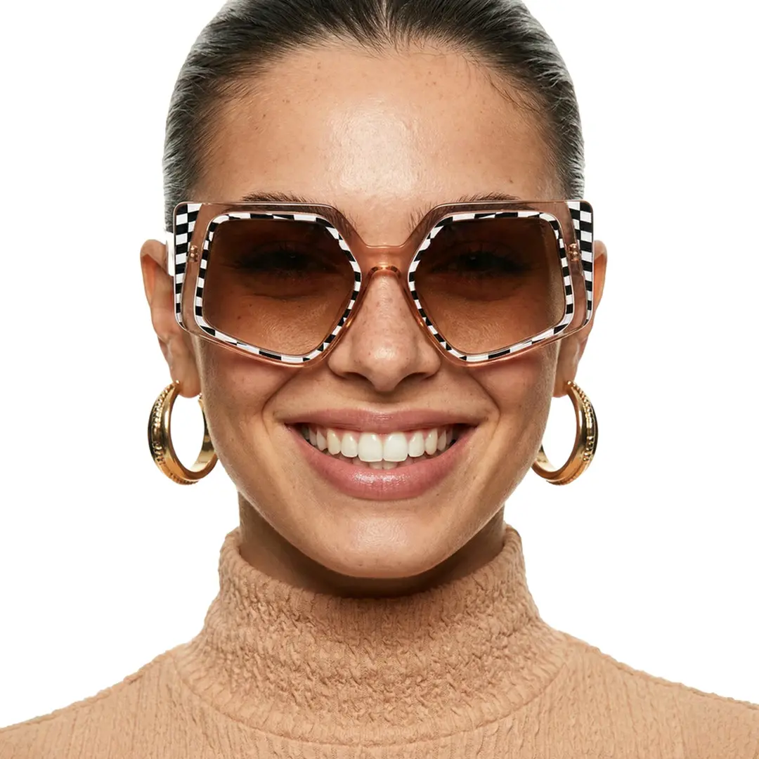 Front view of female wearing brown geometric sunglasses, smiling, GP0222507