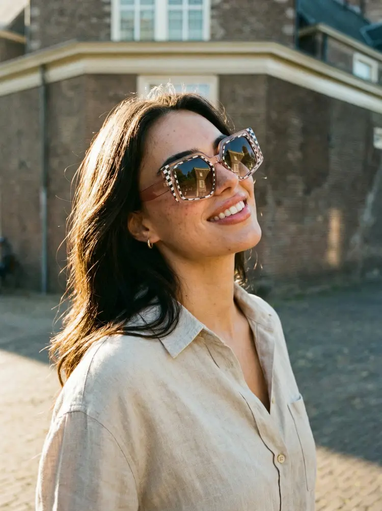 Female model wearing fashion brown geometric pc sunglasses in an outdoor urban street with a vintage brick building background. SPU: GP0222507