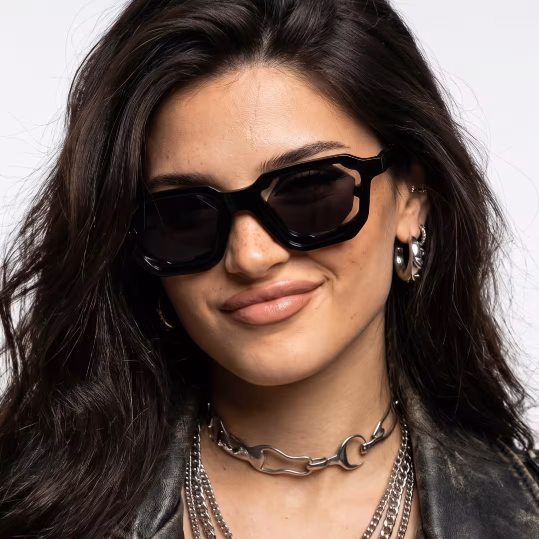 Female wearing fashion black geometric pc sunglasses, giving a subtle smile while looking at camera. SPU: GP0482605