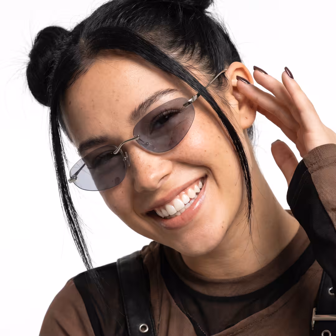 Close-up view of female wearing y2k silver oval sunglasses, smiling, OM0112605