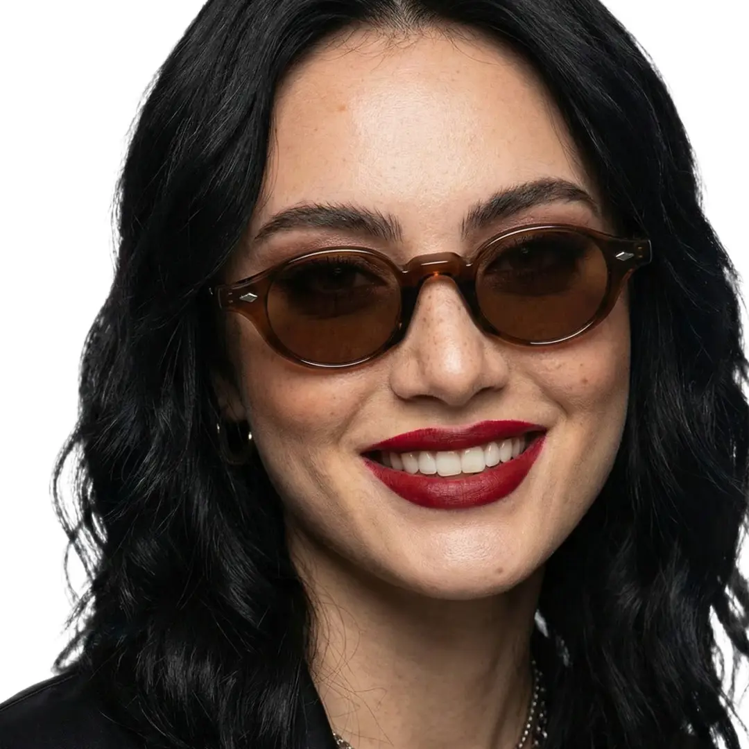Front view of female wearing vintage beige oval sunglasses, natural smile, OP0062505