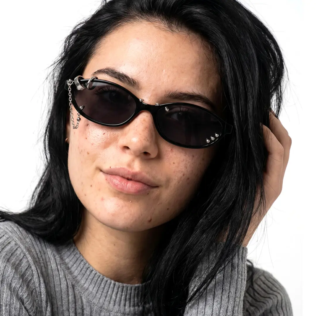 Looking straight ahead view of female wearing silver oval handcrafted polarized sunglasses, hand in hair, neutral expression, OP0092604