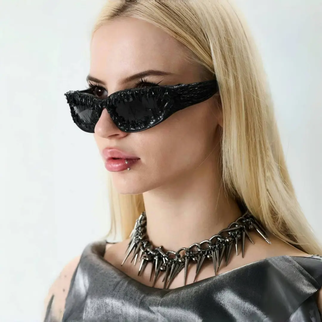 Profile view of female wearing black oval sunglasses, neutral expression, OP0102511