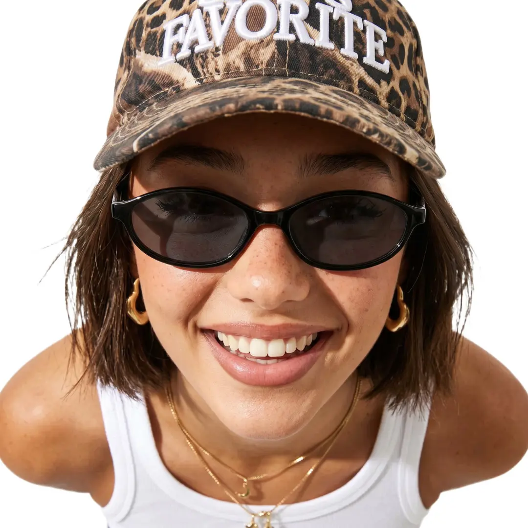 Front view of female wearing y2k black oval sunglasses, smiling, OP0272603