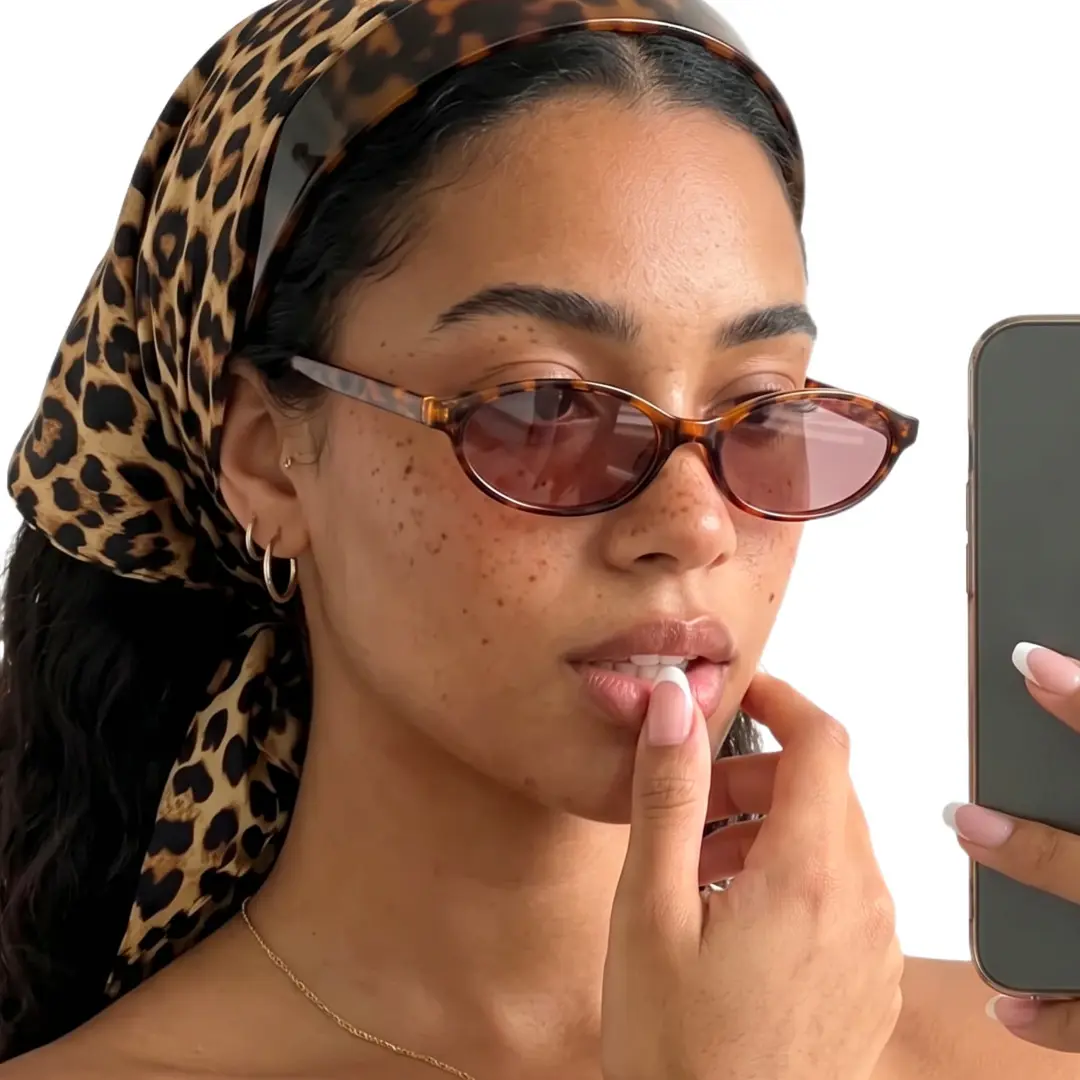 Profile view of female wearing y2k tortoise oval sunglasses, taking a selfie, neutral expression, OP0272603
