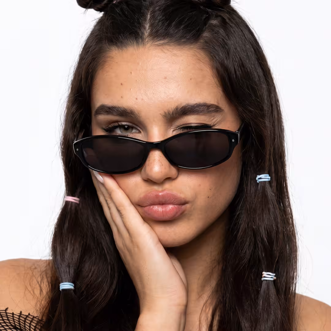 Front view of female wearing y2k black oval sunglasses, pouting, OP0332604