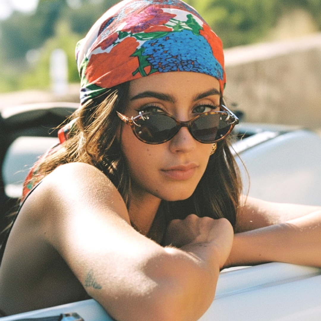 Over-the-shoulder view of female wearing tortoise oval handcrafted polarized sunglasses, natural expression, OR0042509