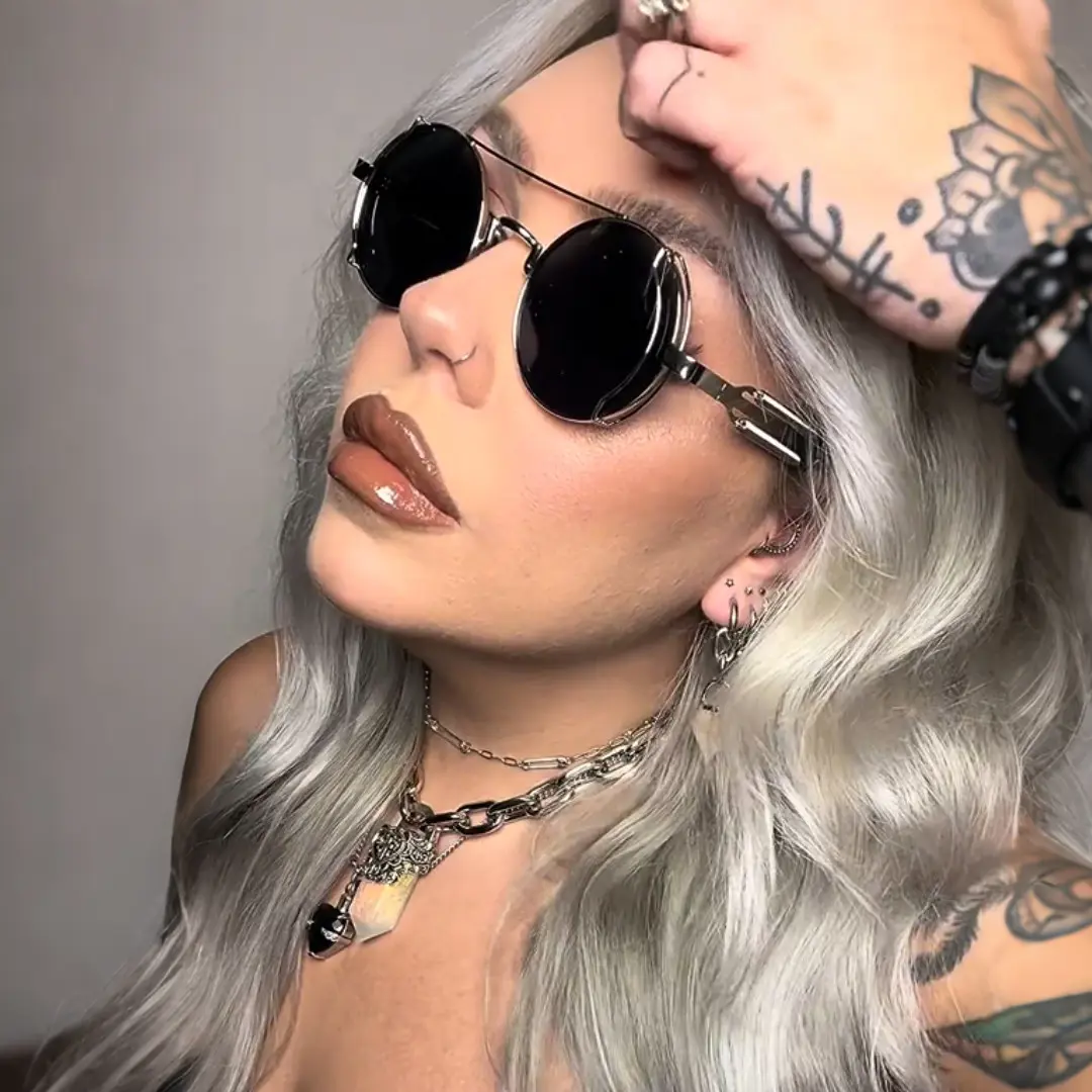 Three-quarter view of female wearing steampunk black round sunglasses, natural expression, RM0102303