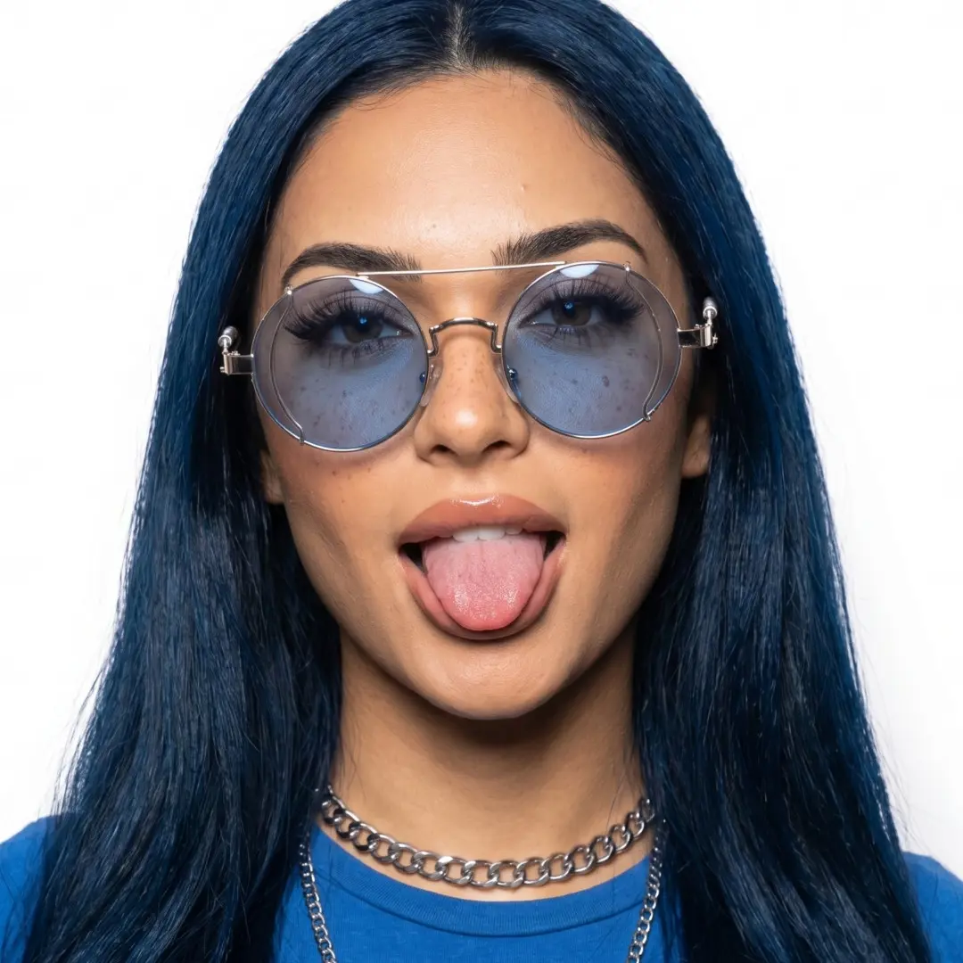 Front view of female wearing steampunk blue round sunglasses, sticking out tongue, confident expression, RM0102303