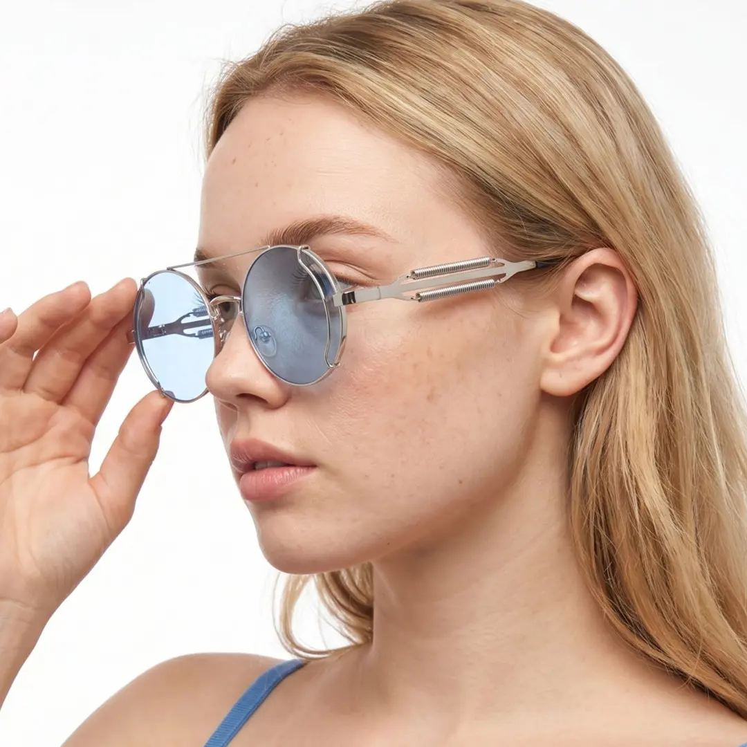 Profile view of female wearing steampunk silver blue round sunglasses, touching frame, neutral expression, RM0102303