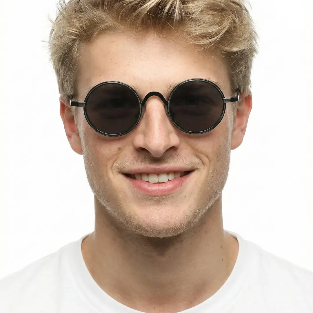 Looking straight ahead view of male wearing black round sunglasses, soft smile, RM0162506