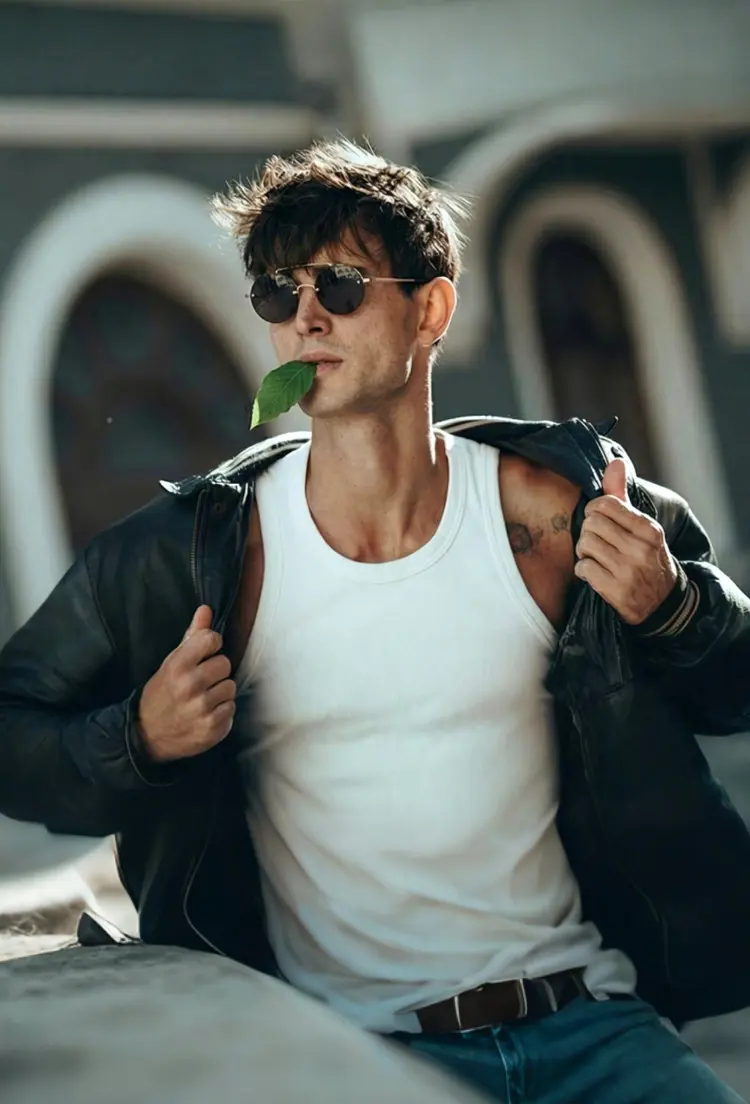 Male model wearing vintage gold round metal sunglasses in an outdoor urban street with European arch architectural background. SPU: RM0252507