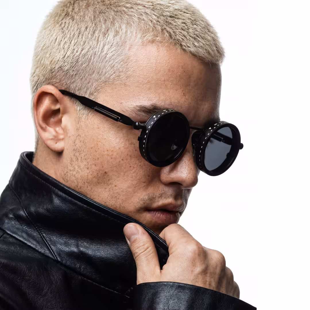 Profile view of male wearing steampunk black round sunglasses, neutral expression, RM0312605