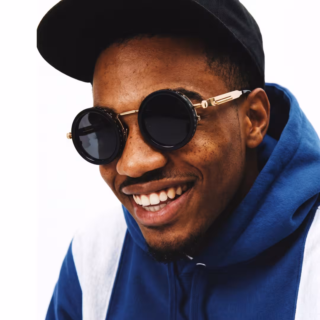 Profile view of male wearing steampunk gold round sunglasses, smiling, RM0312605