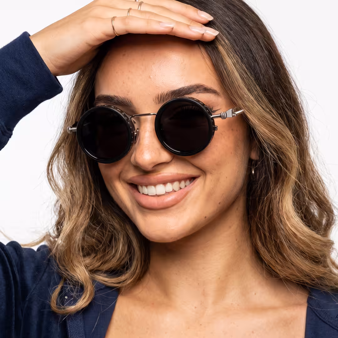 Front view of female wearing steampunk silver round sunglasses, smiling, RM0312605