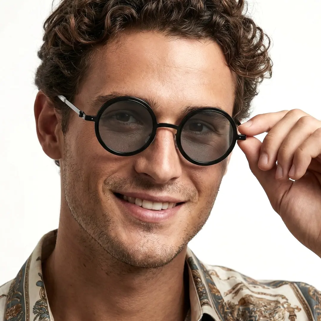 Front view of male wearing black round ND filter sunglasses, touching frame, smiling, RM0322507