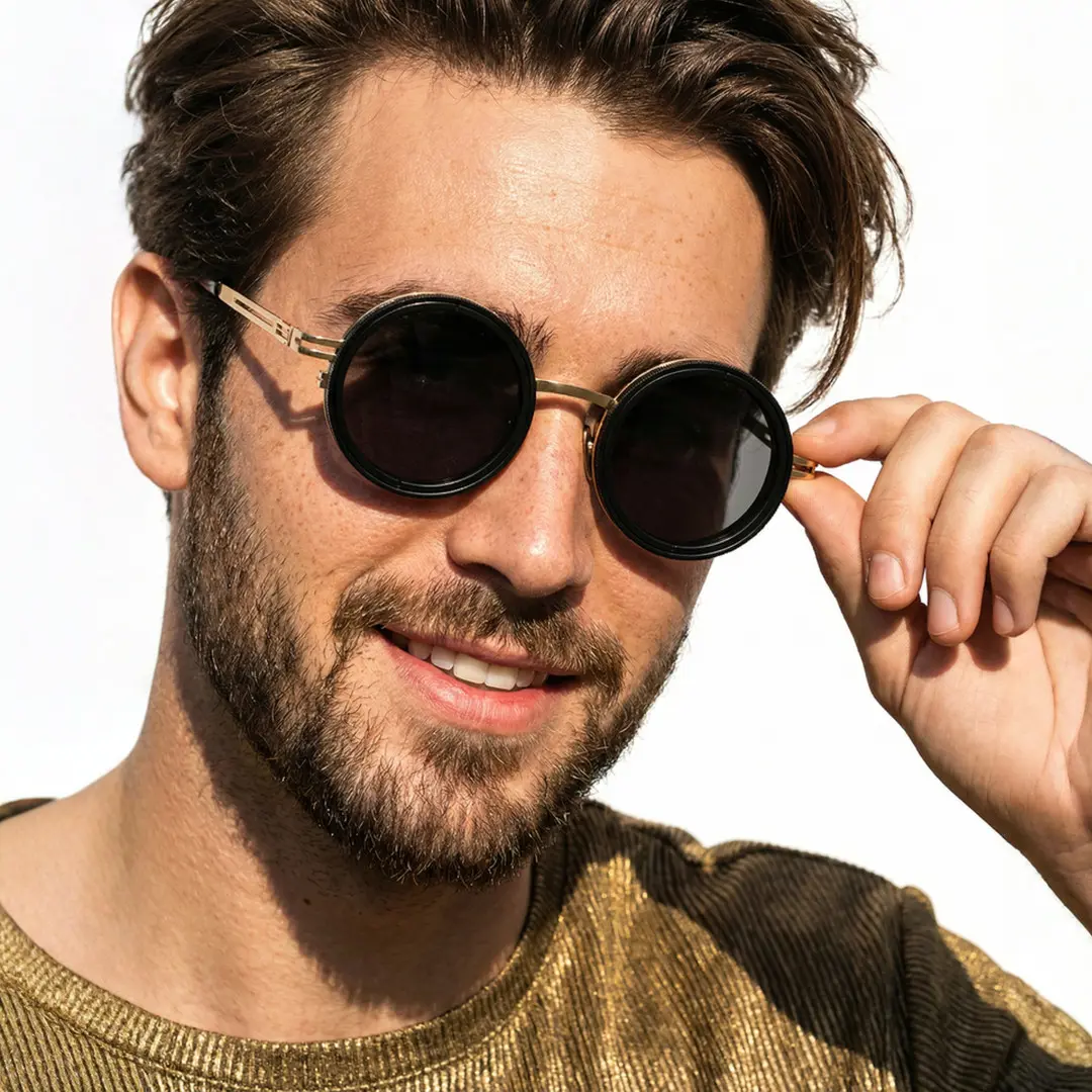 Tilted head view of male wearing steampunk gold round sunglasses, touching frame, friendly smile, RM0352507