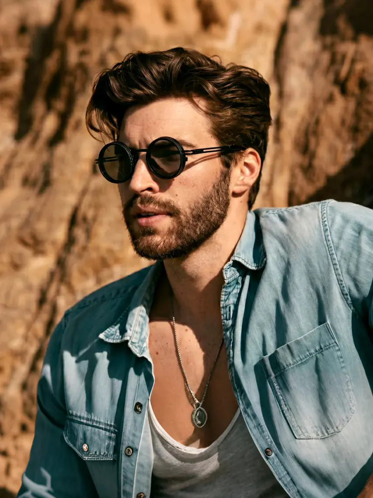 Male model wearing steampunk black round metal magnetic clip on sunglasses in an outdoor rocky desert or cliff setting. SPU: RM0352507
