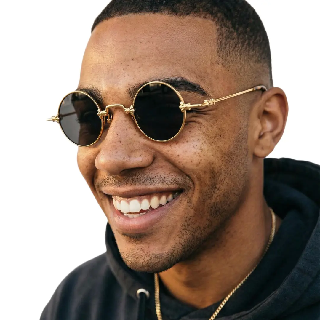 Profile view of male wearing gold round sunglasses, smiling, RM0362505