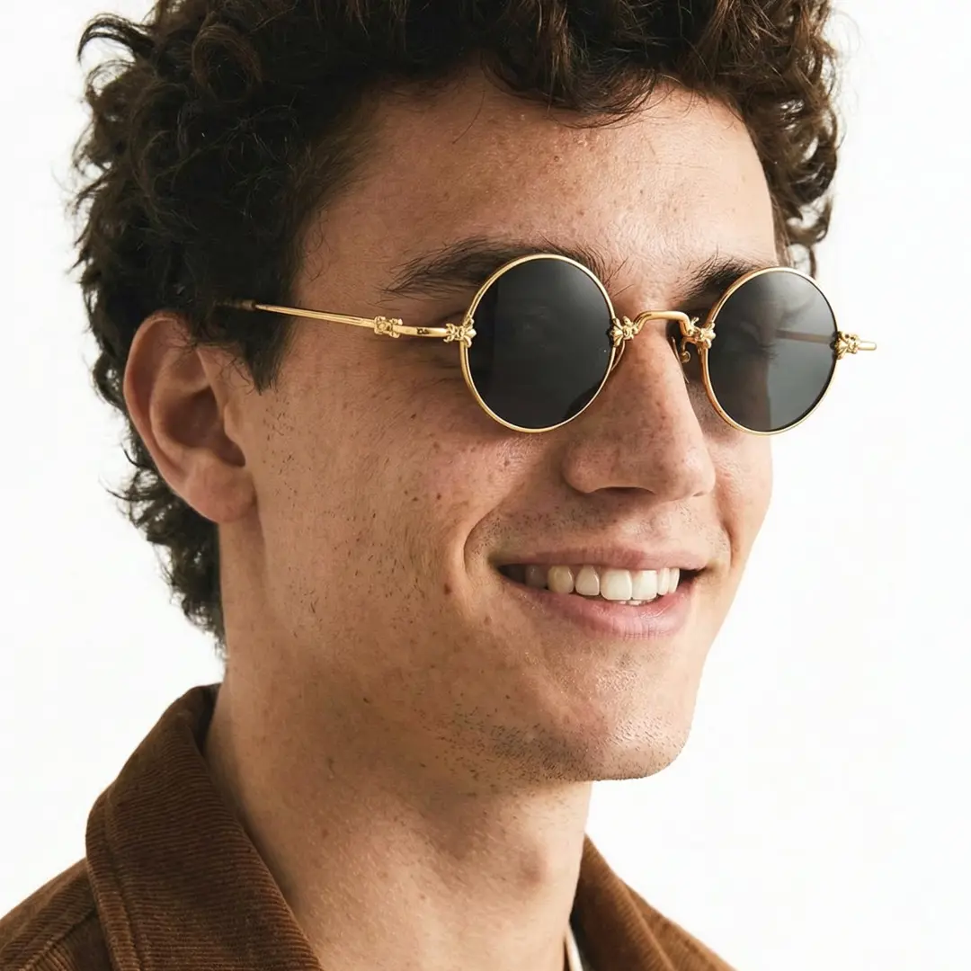 Three-quarter view of male wearing john lennon gold round sunglasses, friendly smile, RM0362505