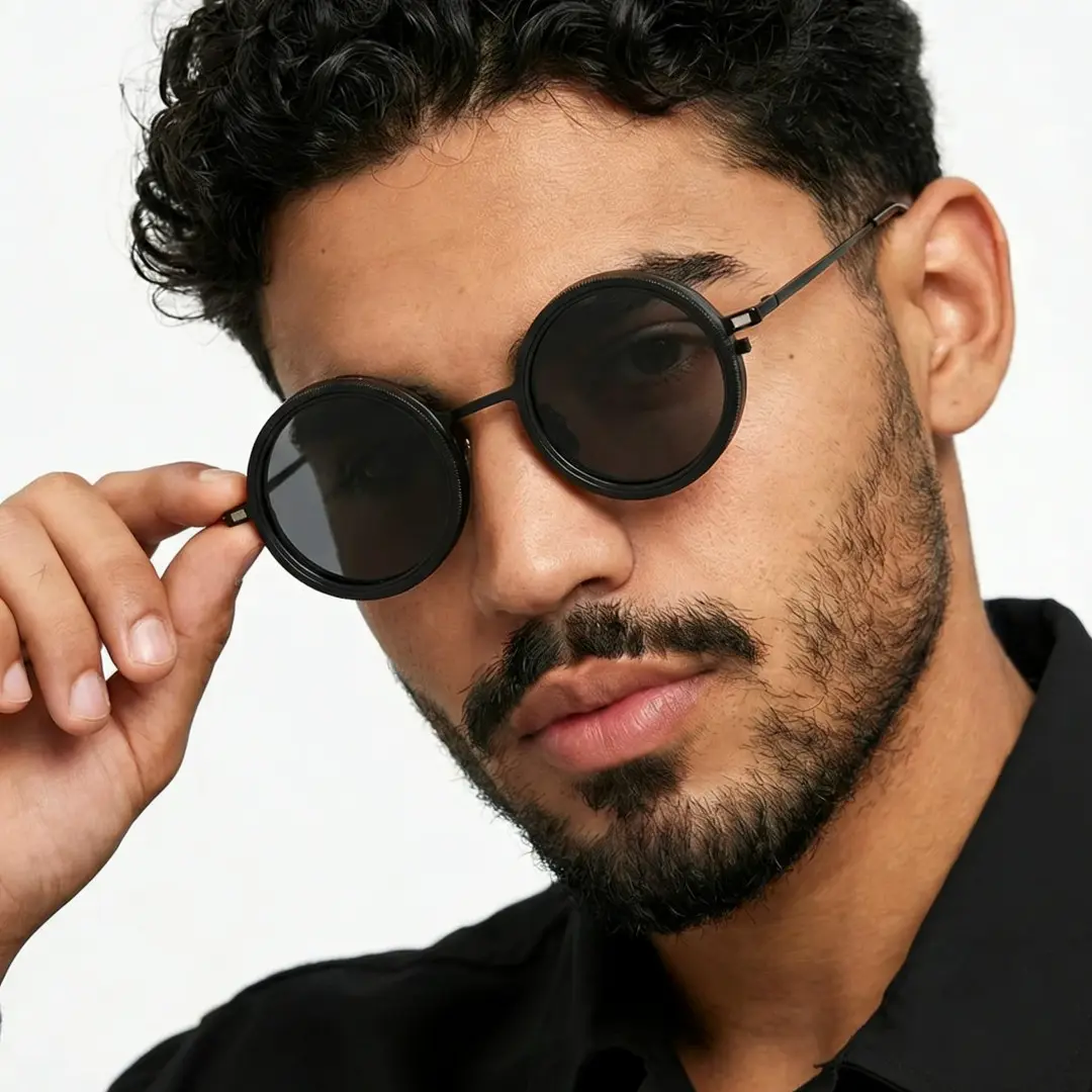 Profile view of male wearing black round magnetic clip-on sunglasses set with interchangeable toppers, adjusting glasses, neutral expression, RM0382507