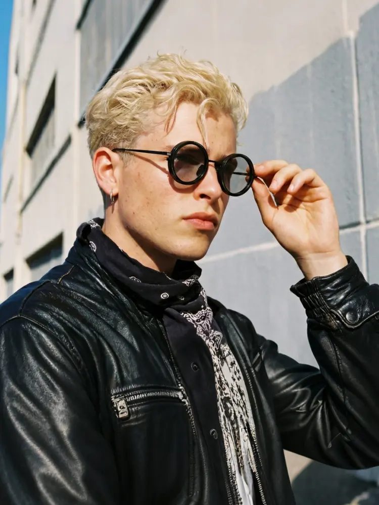 Male model wearing steampunk black round metal magnetic clip on sunglasses in an urban street setting with a building wall. SPU: RM0352507