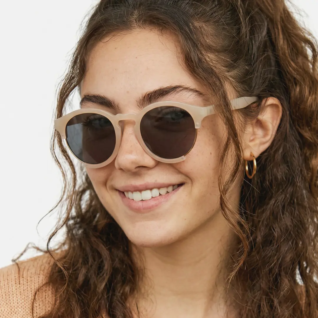 Face close-up view of female wearing pink round sunglasses, wide smile, RR0062402