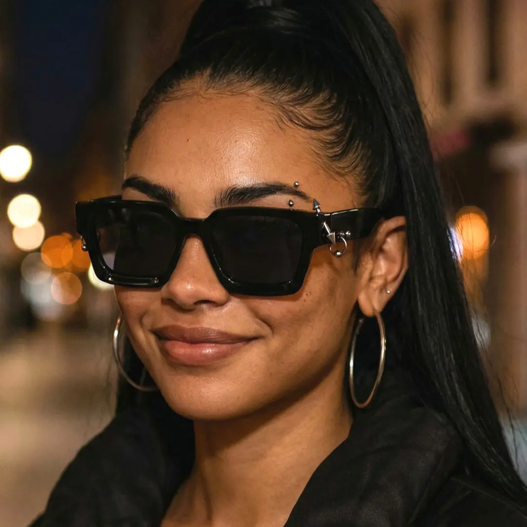 Three-quarter view of female wearing black square sunglasses, smiling, SP0012603
