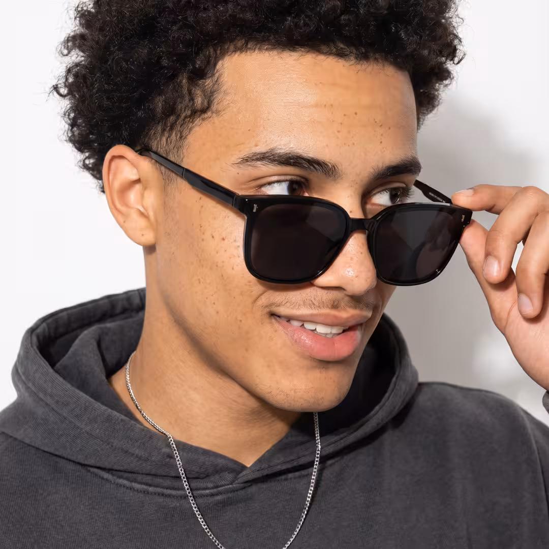 Male wearing black square pc sunglasses, natural smile while touching frame. SPU: SP0302604